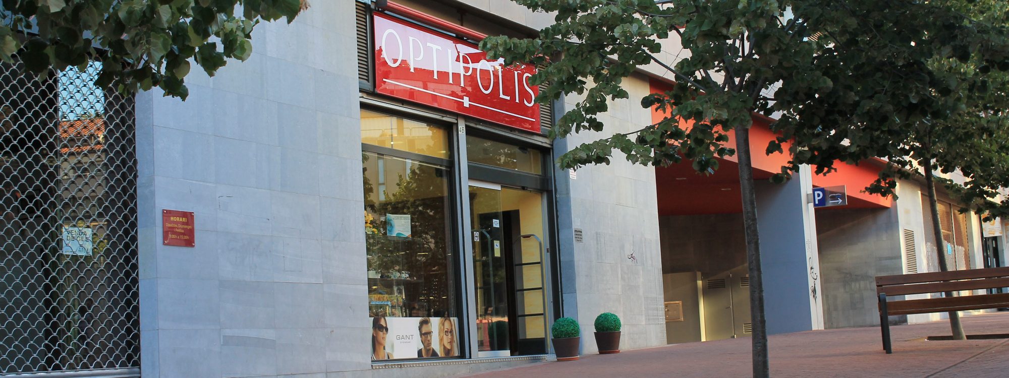 Óptica Optipolis Exterior de la óptica, con cartel en rojo de OPTIPOLIS.