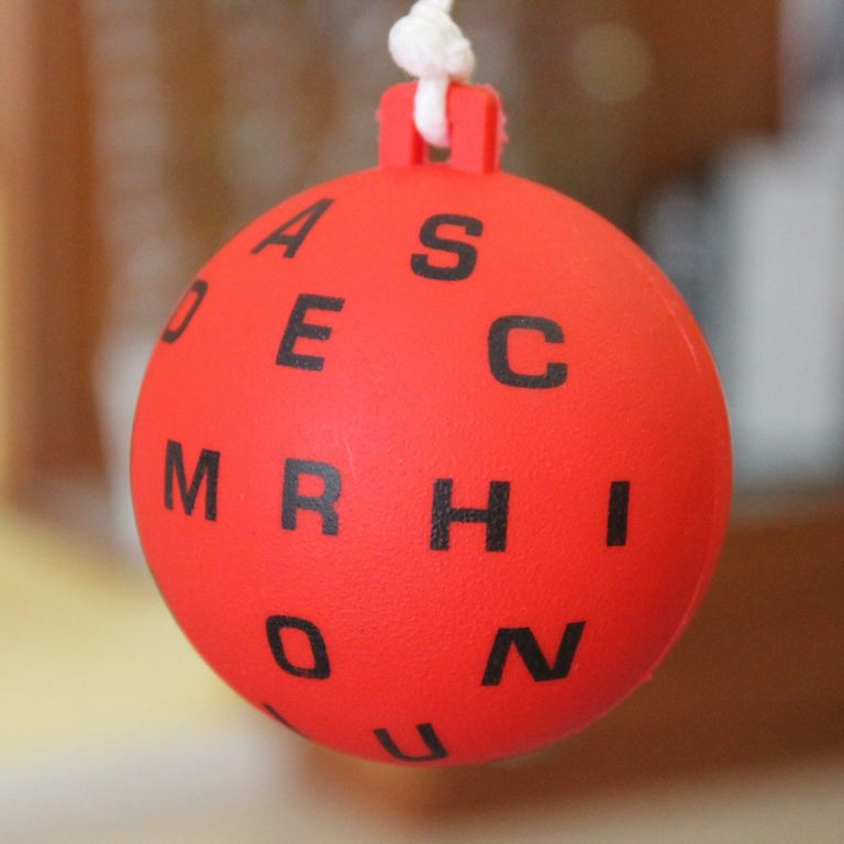 Terapia visual Pelota roja con letras negras utilizada en terapias visuales.